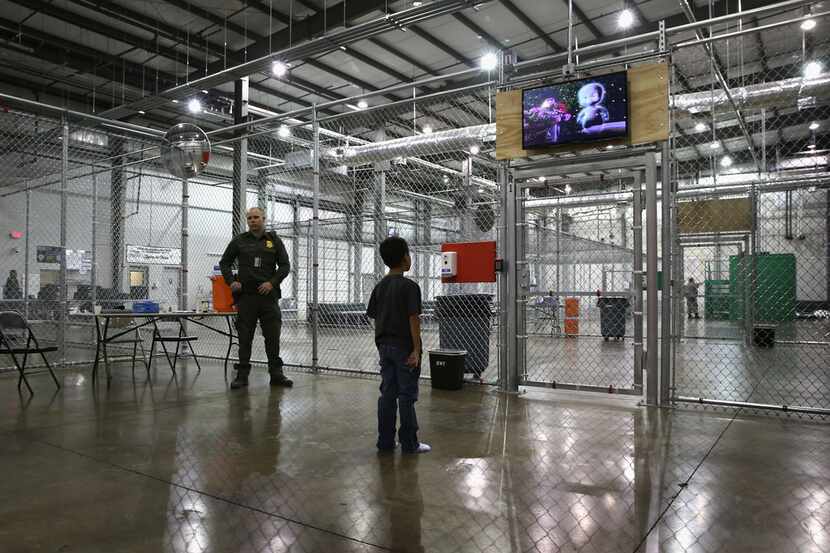 A boy from Honduras watches a movie at a detention facility run by the U.S. Border Patrol....