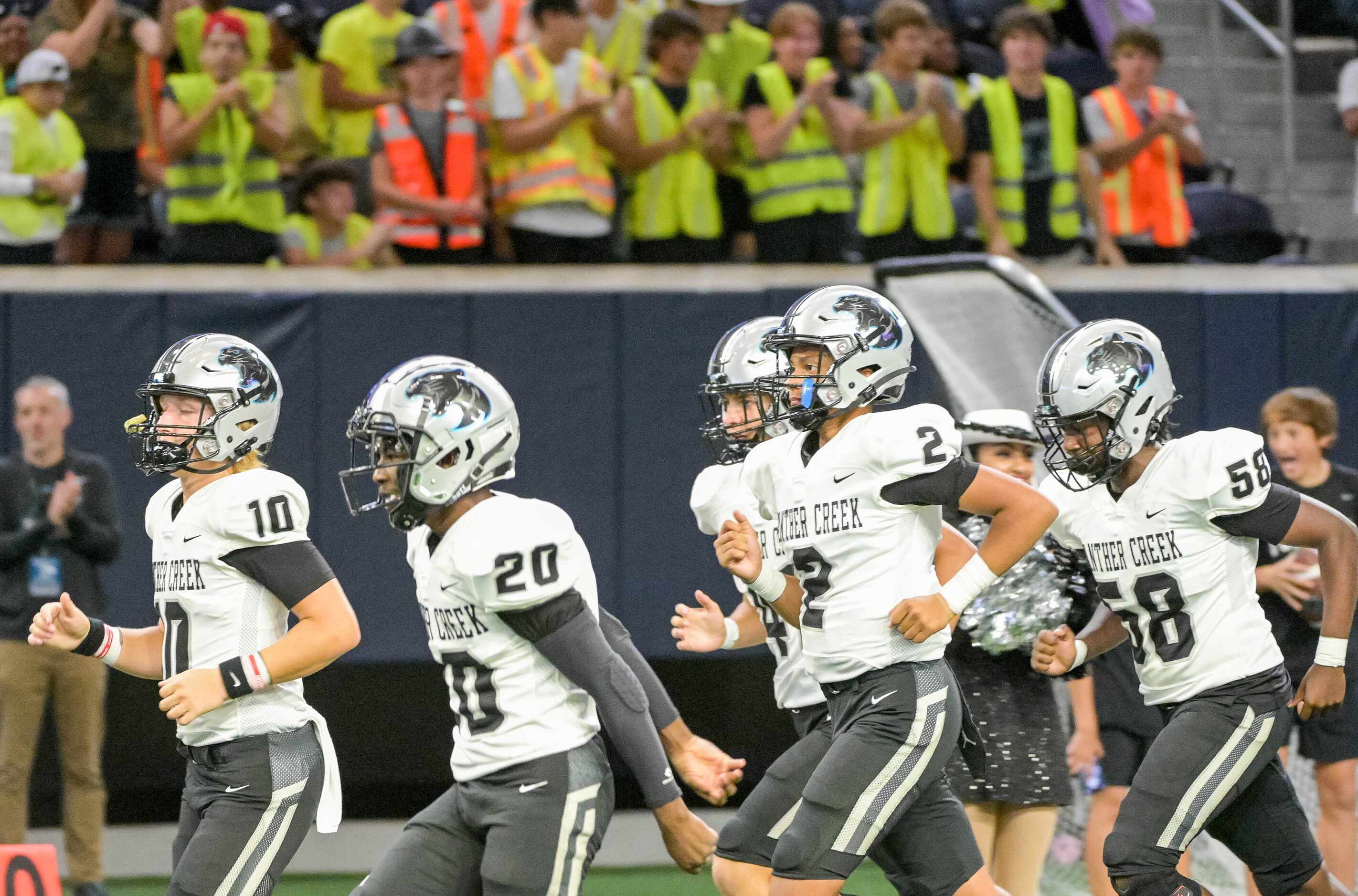 Panther Creek players run onto the field before a high school football game between  Frisco...