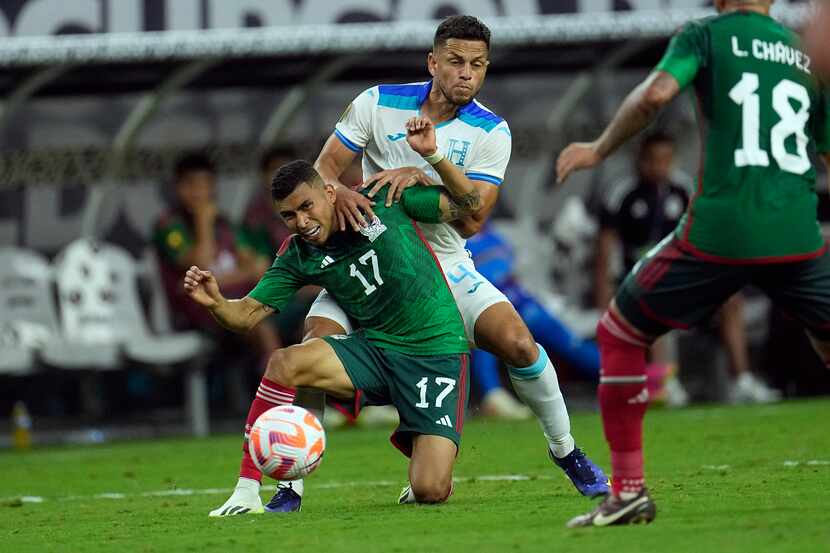 El jugador de la selección mexicana, Orbelín Pineda (17), recibe una falta del hondureño...