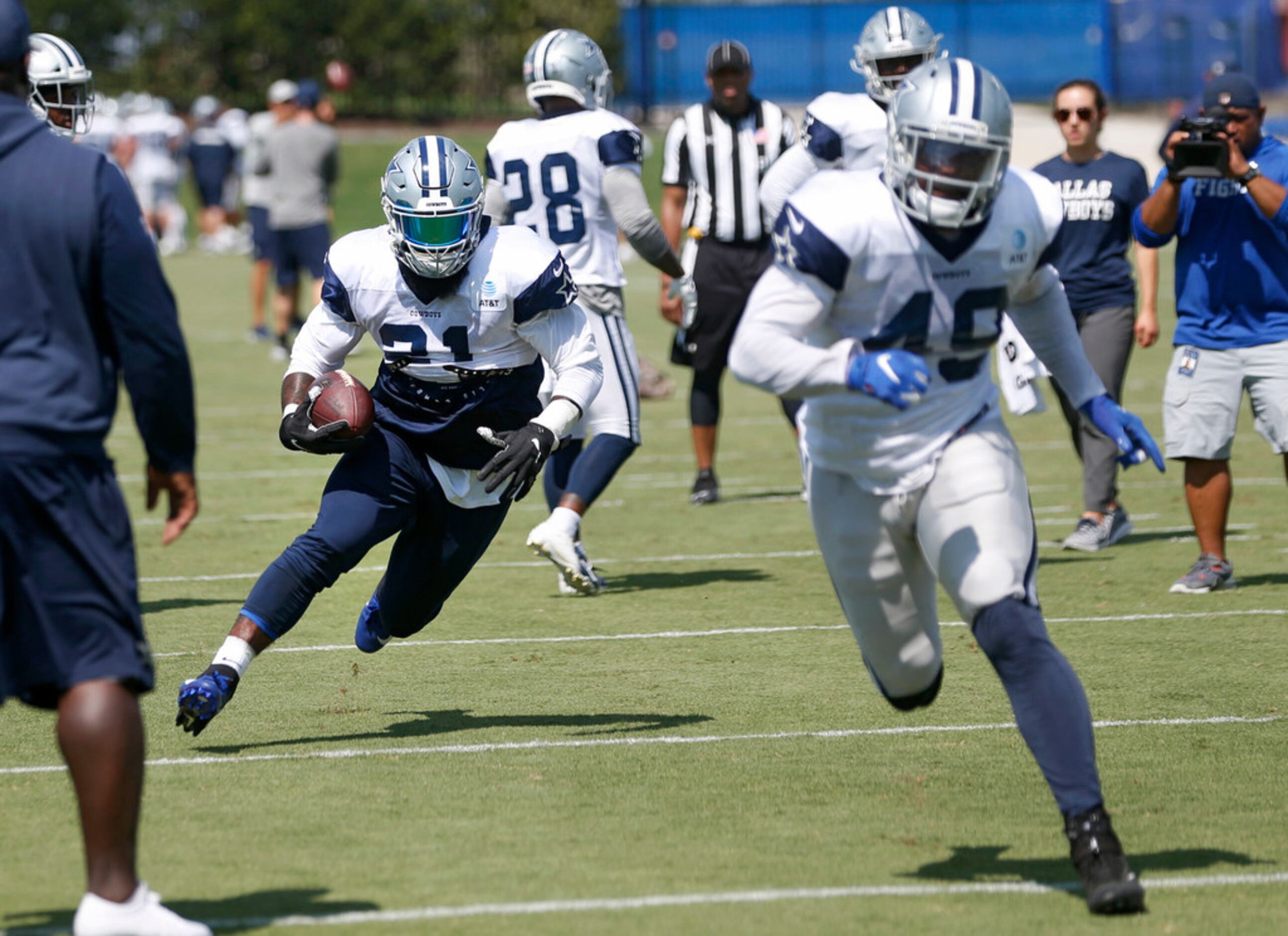 Dallas Cowboys running back Ezekiel Elliott (21, left) runs up the field as Dallas Cowboys...
