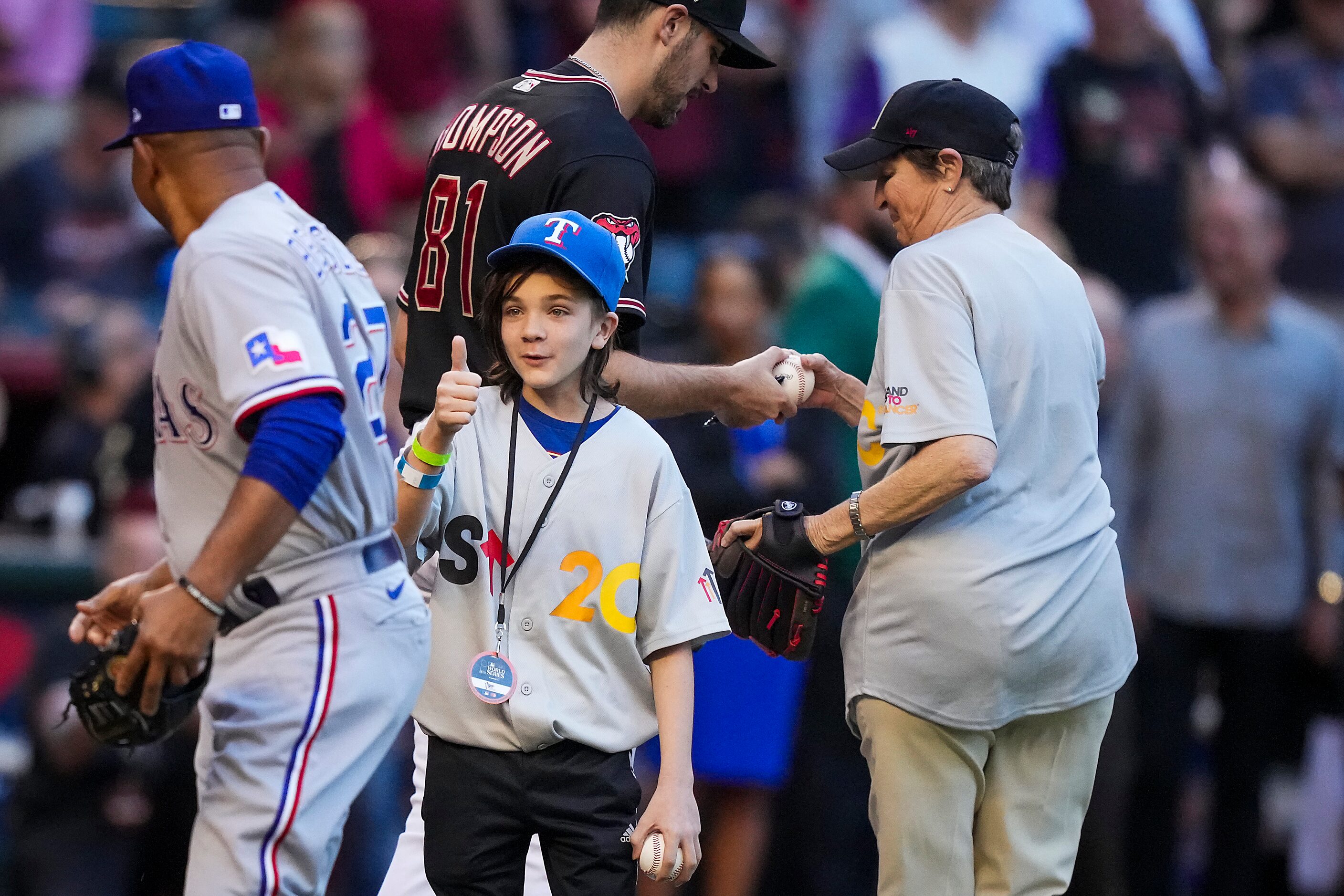 Maddox Carmean, 13, gives a thumbs up to Texas Rangers third base coach Tony Beasley after...