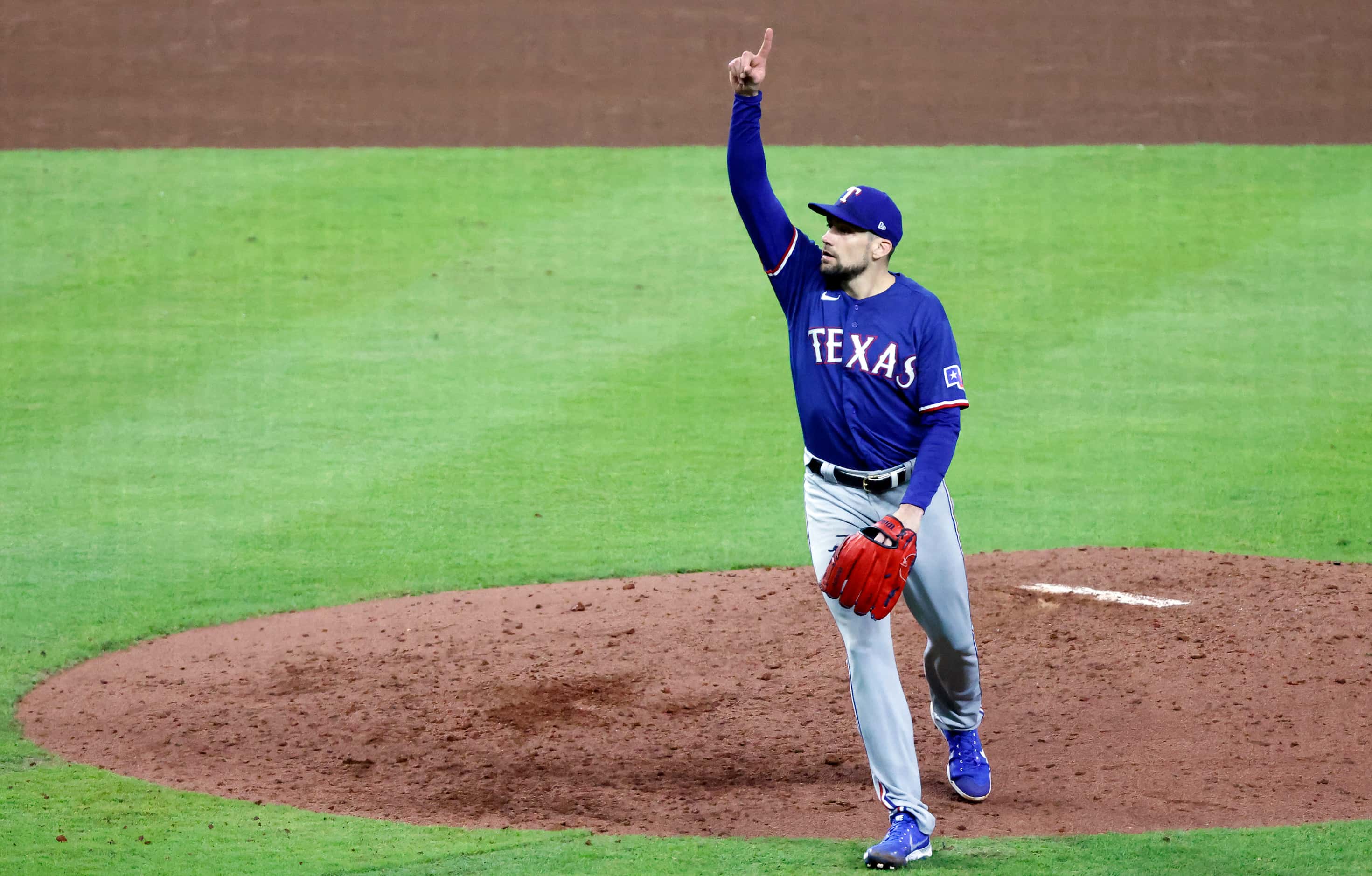 Texas Rangers starting pitcher Nathan Eovaldi (17) points up to a foul ball and eventual out...