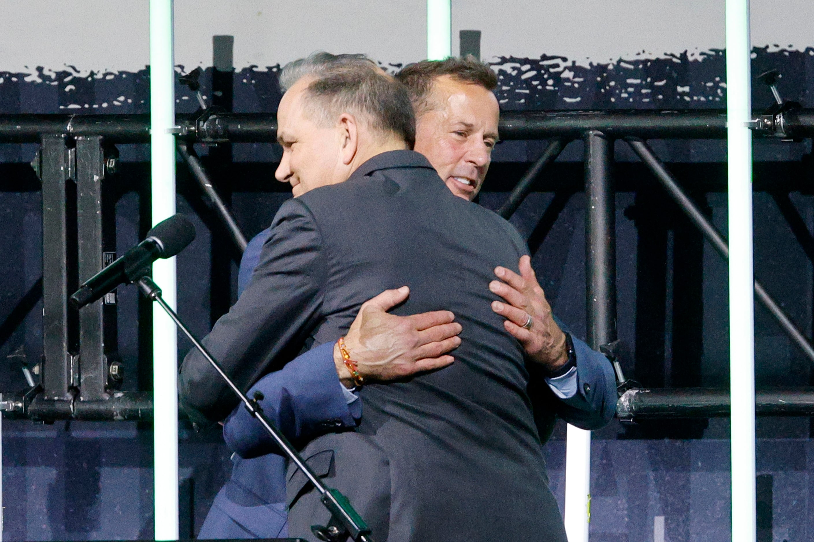 Dallas Stars legend Mike Modano receives a hug from Stars Analyst Daryl Reaugh during the...