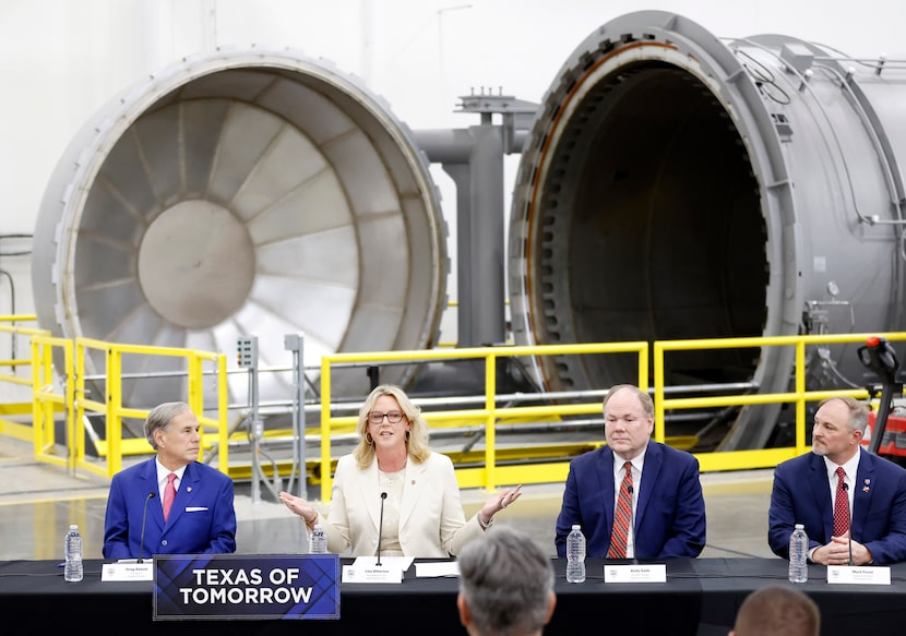 Before a large autoclave, Texas Governor Greg Abbott (left) listens to Bell Textron CEO Lisa...