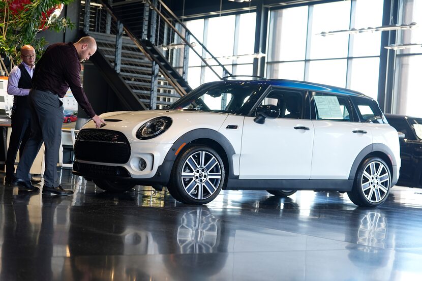 ARCHIVO - Vendedores examinan un vehículo utilitario Cooper Clubman S 2024 no vendido, en...