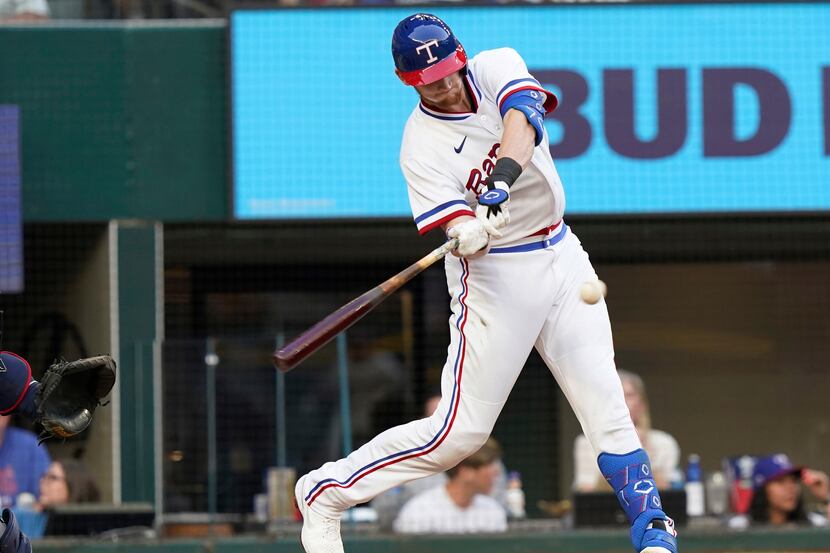 Texas Rangers Sam Huff swings for an RBI single in front of Atlanta Braves catcher Travis...