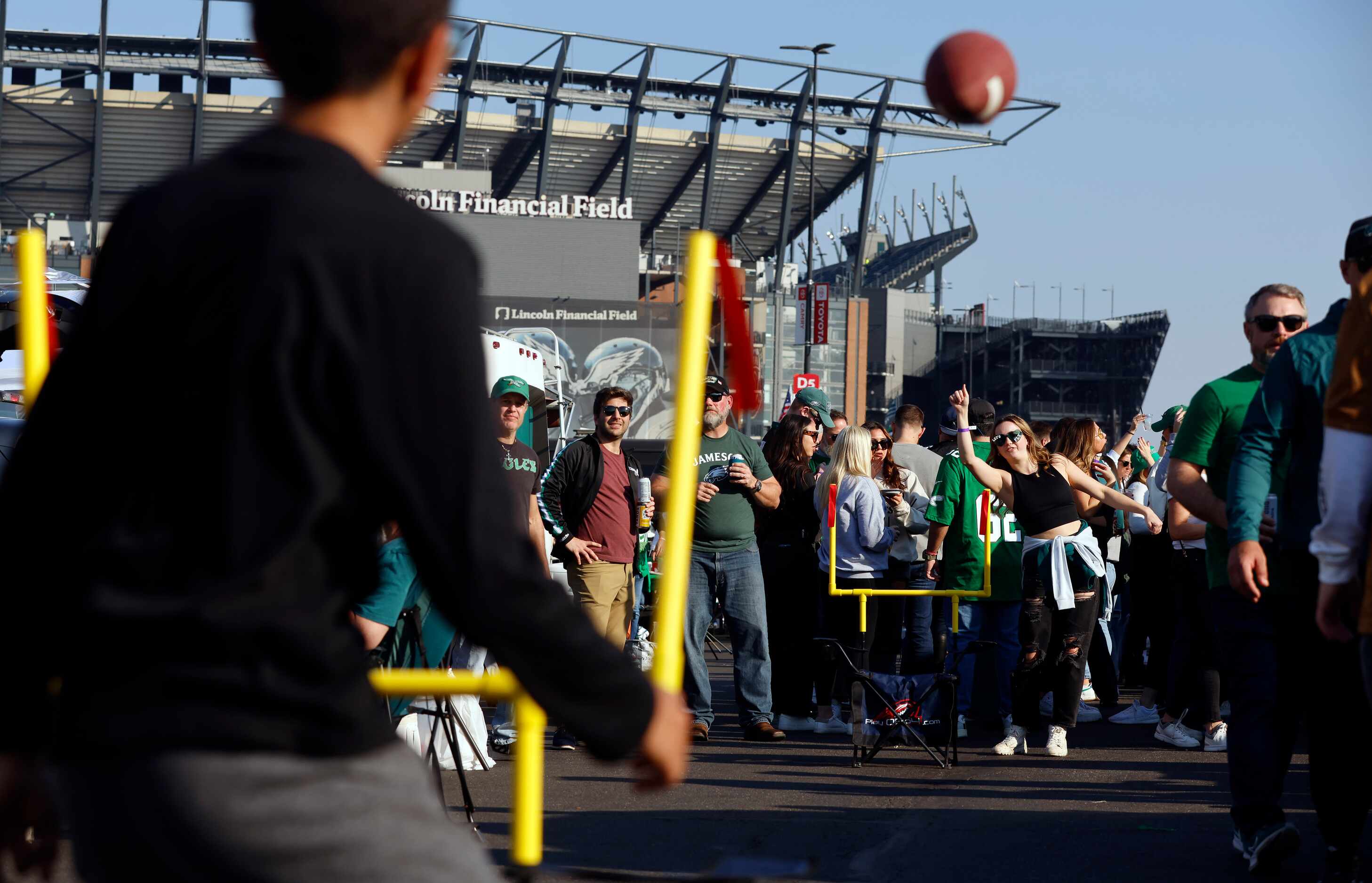 Philadelphia Eagles fan Alyssa Moon attempts to throw a football between the goal posts at a...