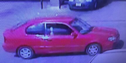 The robber fled in a red two-door sedan.