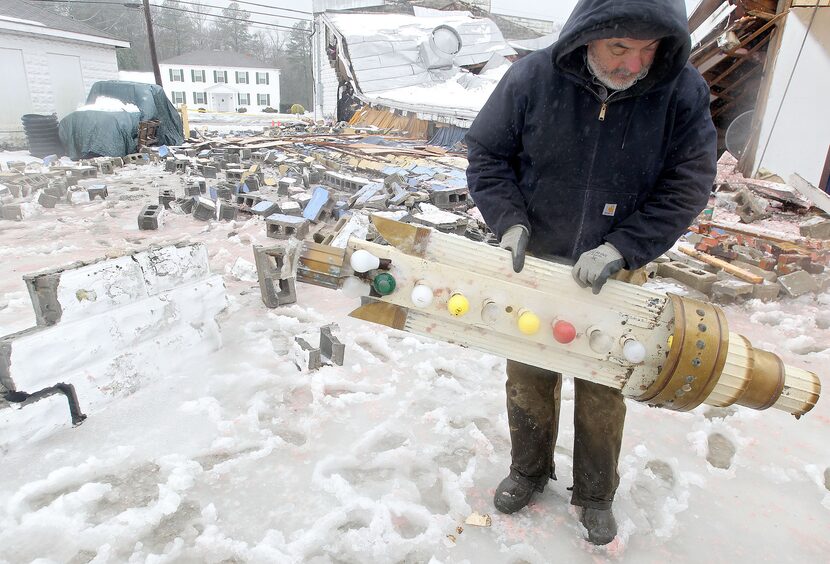  Charlie Carter holds a lighting fixture he salvaged from the rubble of Donk's Theater in...