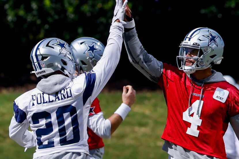 Dallas Cowboys quarterback Dak Prescott (4) high fives Dallas Cowboys running back Tony...