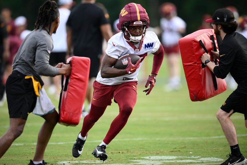 Washington Commanders wide receiver Terry McLaurin, center, works out during NFL football...