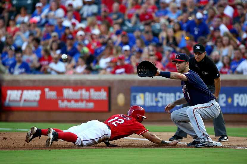 ARLINGTON, TX - JULY 07: Rougned Odor #12 of the Texas Rangers dives safely back to first...