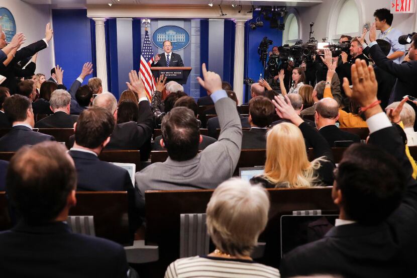 FILE - In this Feb. 22, 2017, file photo, reporters raise their hands as White House press...
