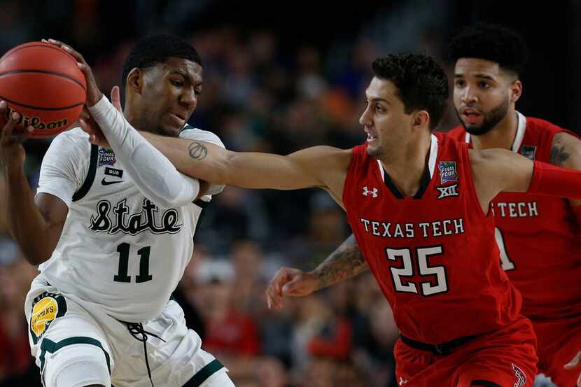 Texas Tech's #25 Davide Moretti, pressures Michigan State's #11 Aaron Henry during the first...