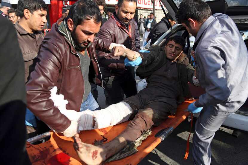 An injured man is moved to a stretcher outside a hospital after a suicide attack in Kabul,...