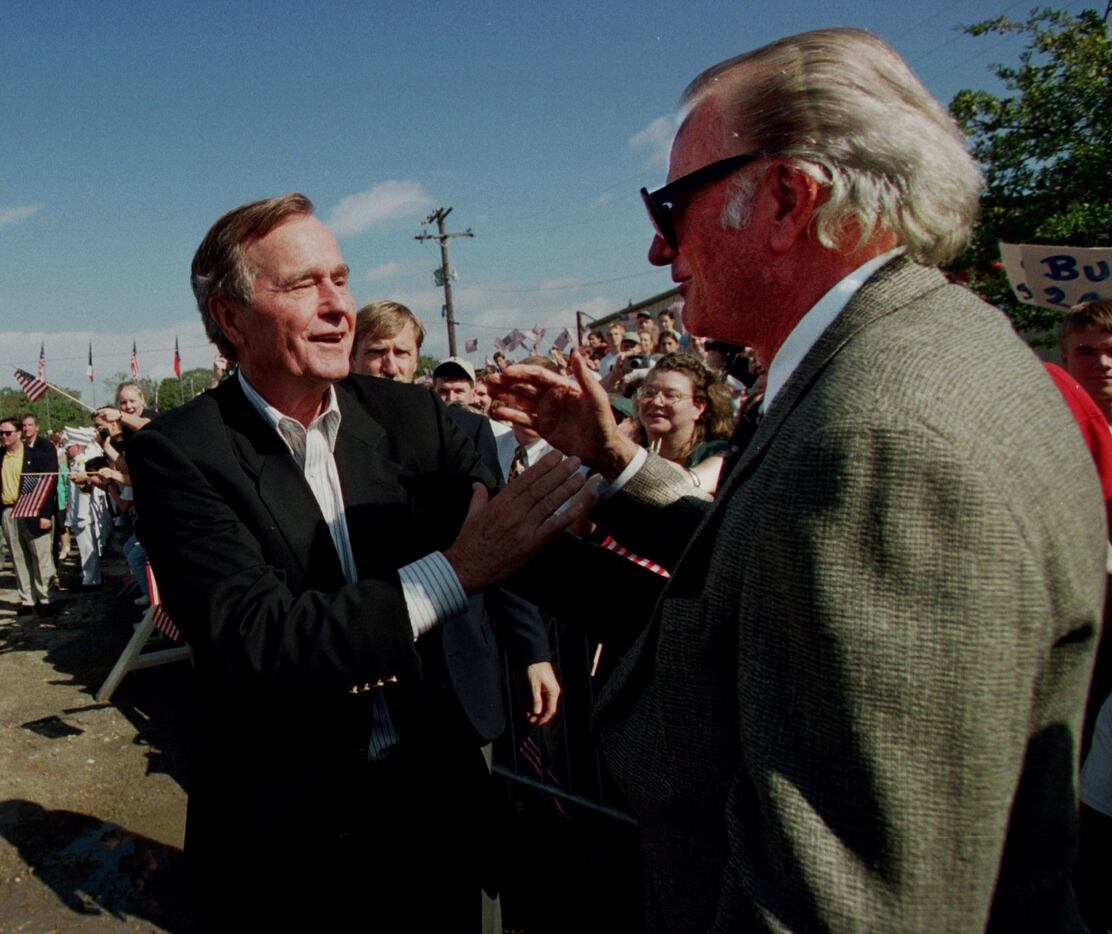 Former President George  Bush greets the Rev. Billy Graham on Nov. 5, 1997, after arriving...