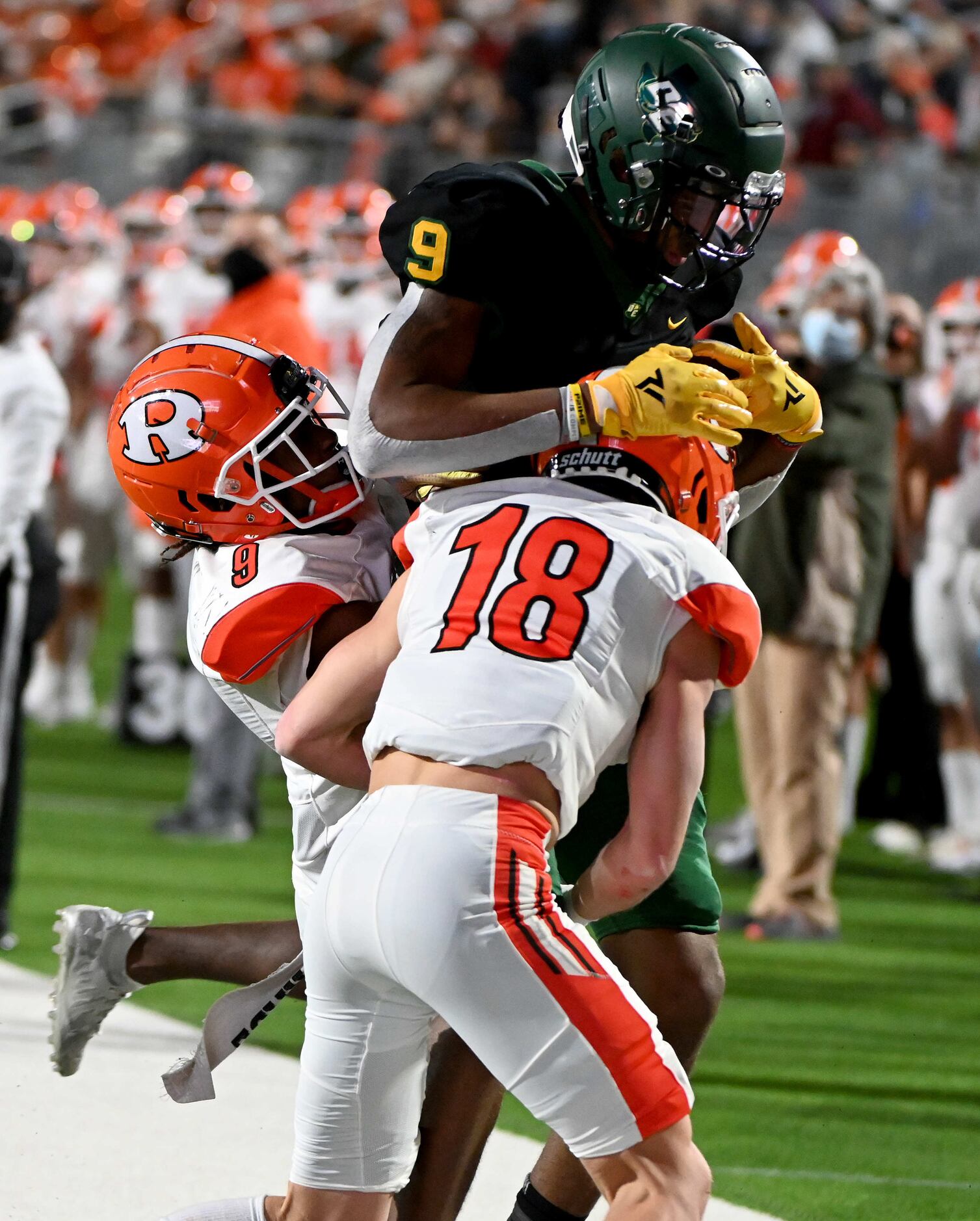 DeSoto’s Jerand Bradley is carried out of bounds by Rockwall’s Dariel Brown (9) and Kade...
