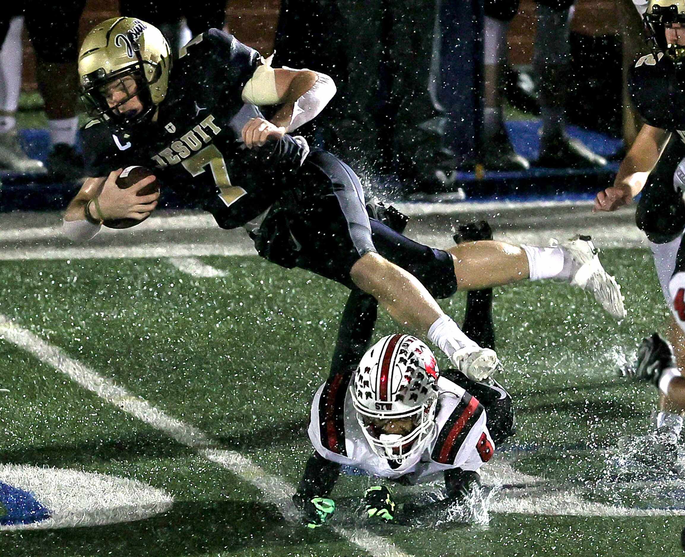 Jesuit wide receiver Jake Musso (7) gets tripped up by MacArthur cornerback Henry Ford (8)...