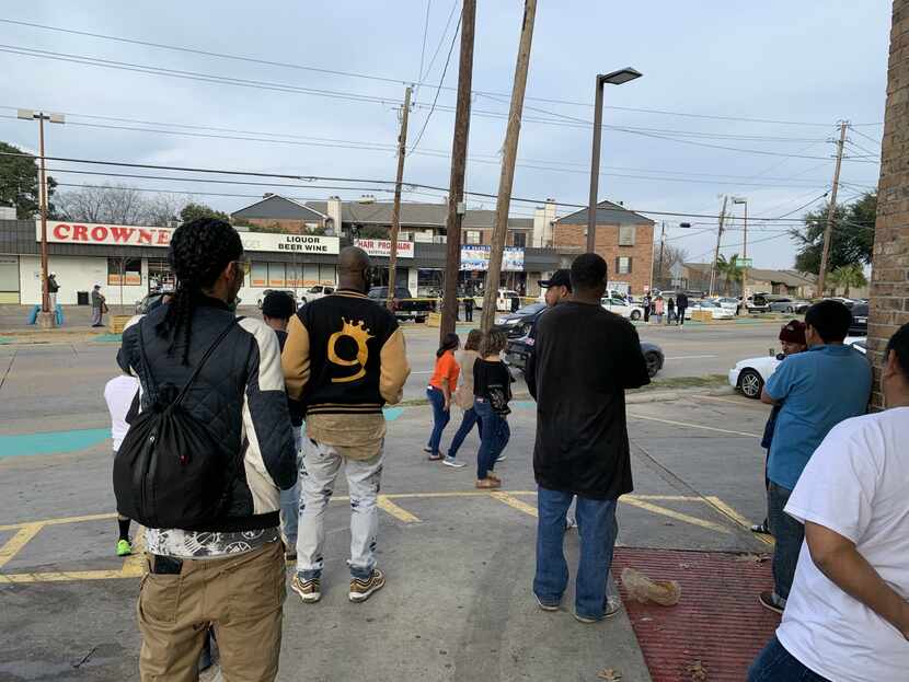 Onlookers gathered to view the crime scene from the 7-Eleven across Park Lane Sunday afternoon.