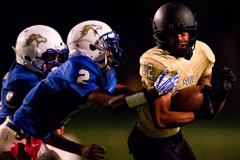 South Oak Cliff wide receiver Courtline Flowers (12) carries the ball as he is defended by...
