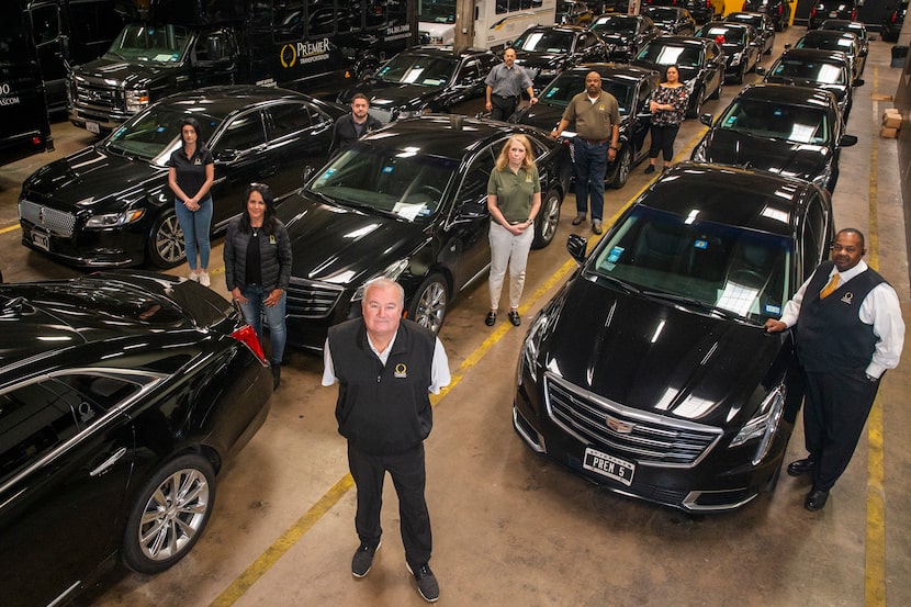 Premier Transportation owner Eric Devlin (center) and his employees pose at the company's...