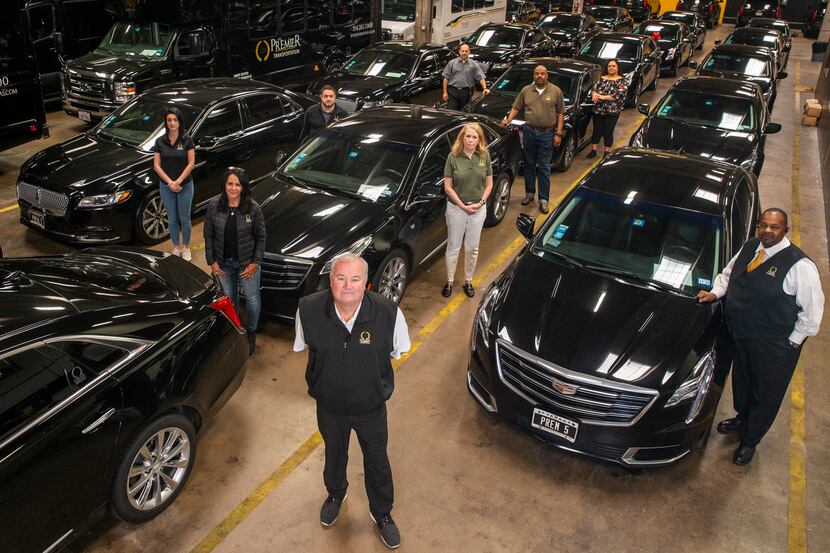 Premier Transportation owner Eric Devlin (center) and his employees pose at the company's...