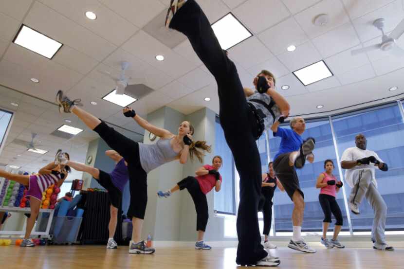 Employees of Alliance Data take part in the 15/15/15 workout class in the company's on site...