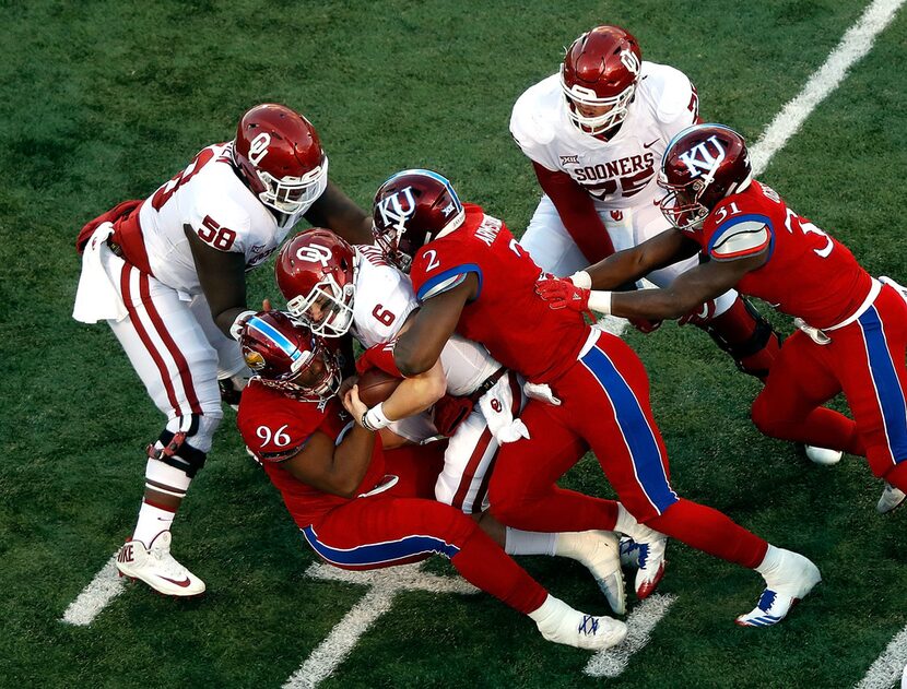 LAWRENCE, KS - NOVEMBER 18:  Quarterback Baker Mayfield #6 of the Oklahoma Sooners is sacked...