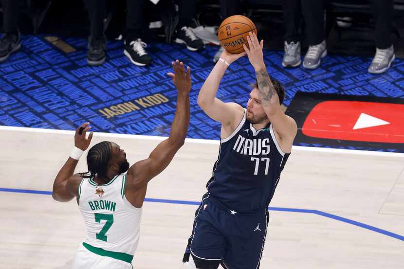 Dallas Mavericks guard Luka Doncic (77) shoots over Boston Celtics guard Jaylen Brown (7)...