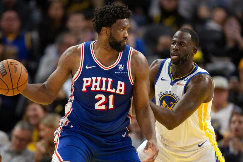 Philadelphia 76ers center Joel Embiid (21) looks to pass around Golden State Warriors...