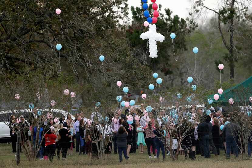 Balloons are released Nov. 15 at a graveside service for members of the Holcombe family who...