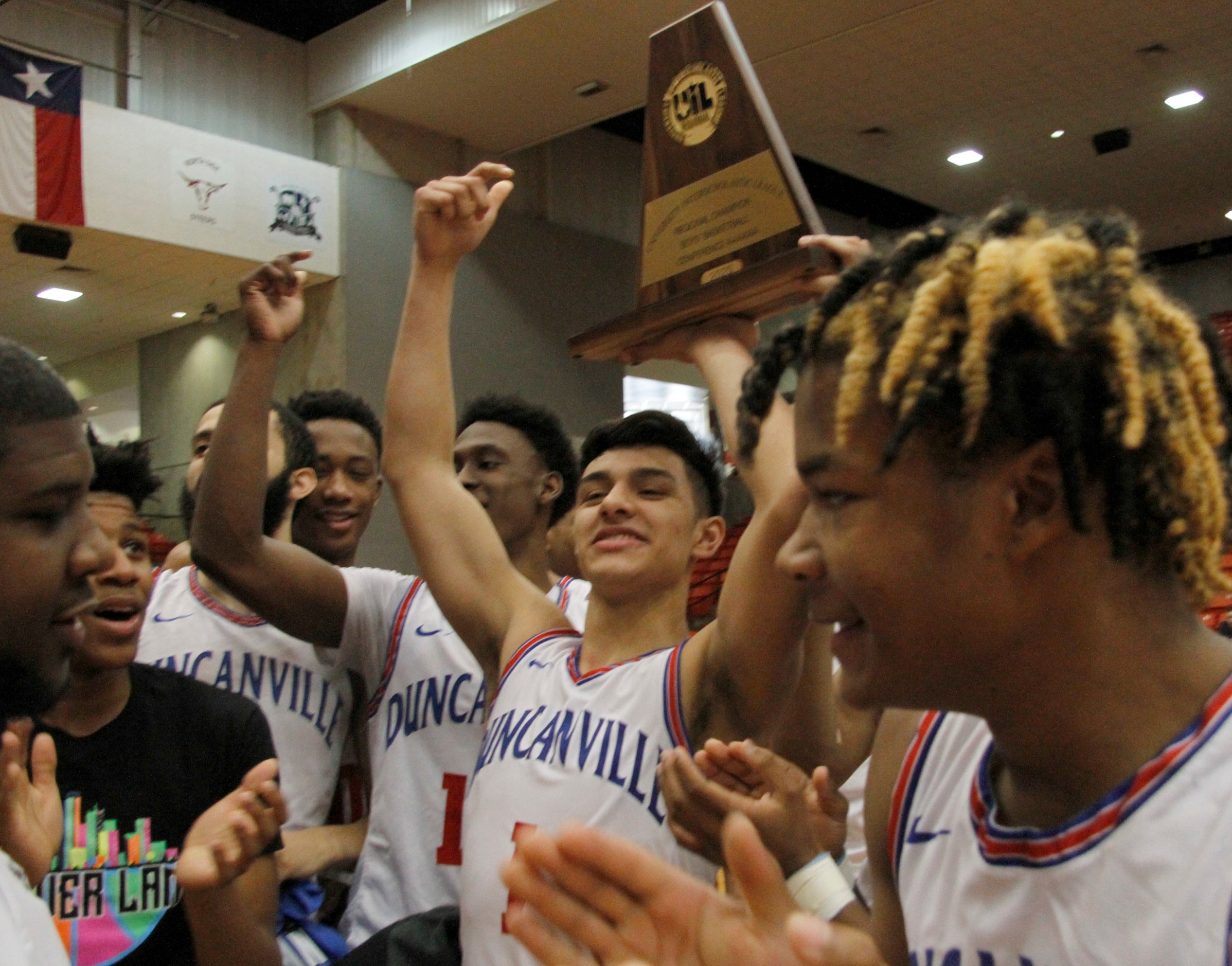 Duncanville guard Cedric Baty (1) raises the Class 6A Region 1 championship trophy as he...