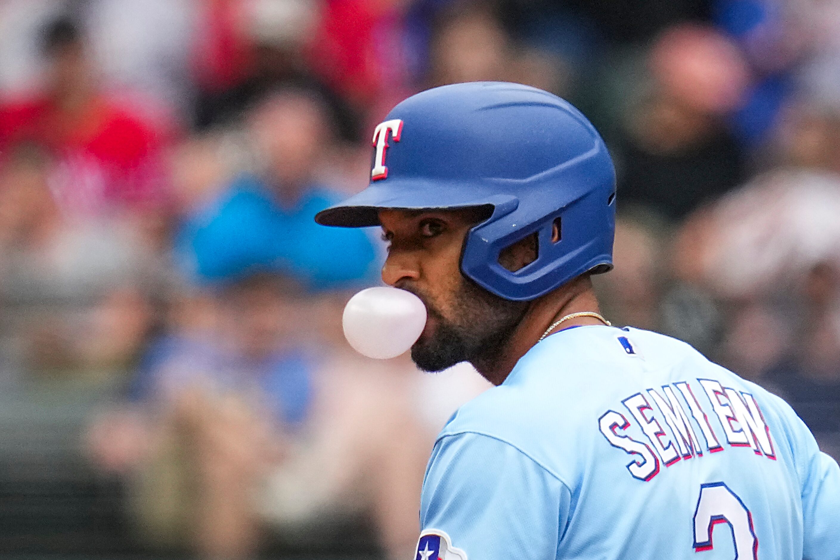 Texas Rangers second baseman Marcus Semien blows a bubble while taking a lead off of second...