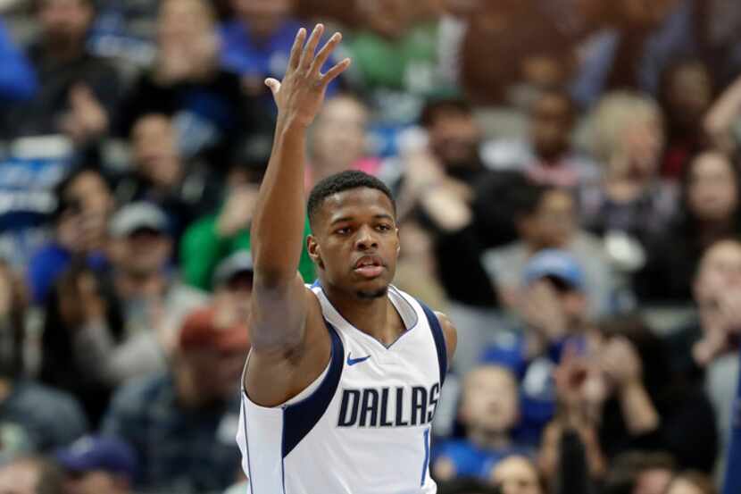 Dallas Mavericks' Dennis Smith Jr. celebrates after dunking on a breakaway play in the first...