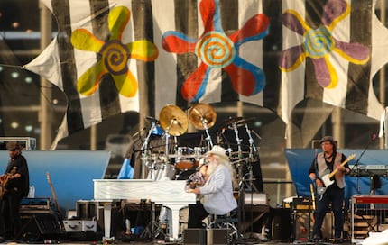 Singer Leon Russell (center) plays the piano and sings during his performance on the...