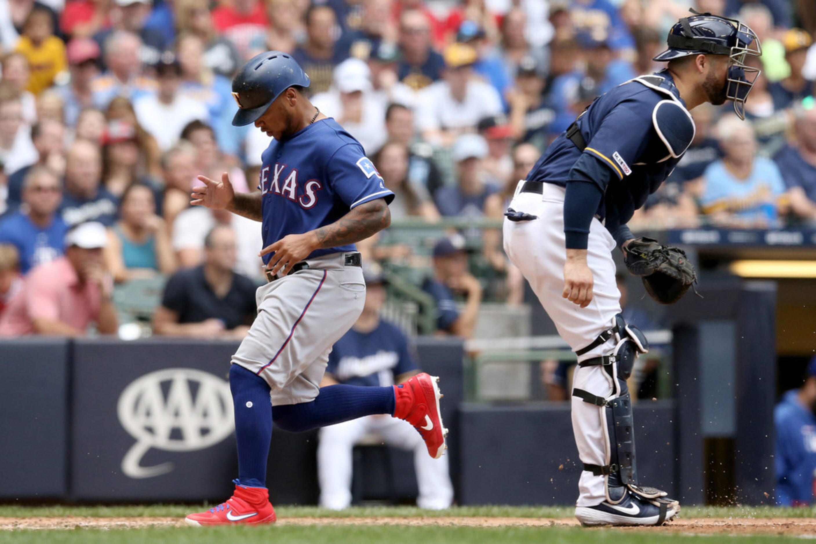 MILWAUKEE, WISCONSIN - AUGUST 11:  Willie Calhoun #5 of the Texas Rangers scores a run past...