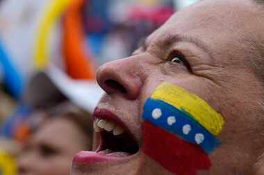 A supporter of opposition presidential candidate Edmundo Gonzalez cheers as hundreds wait...