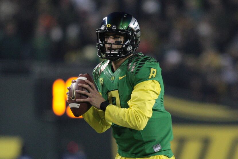 Oregon quarterback Marcus Mariota (8) throws a pass against Oregon State in a 36-35 win....