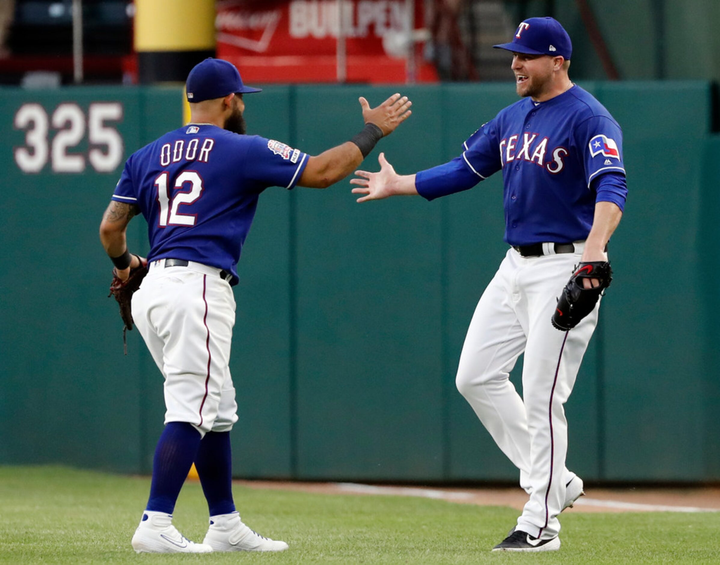 Texas Rangers' Rougned Odor (12) and Shawn Kelley, right, celebrate after the final out of...