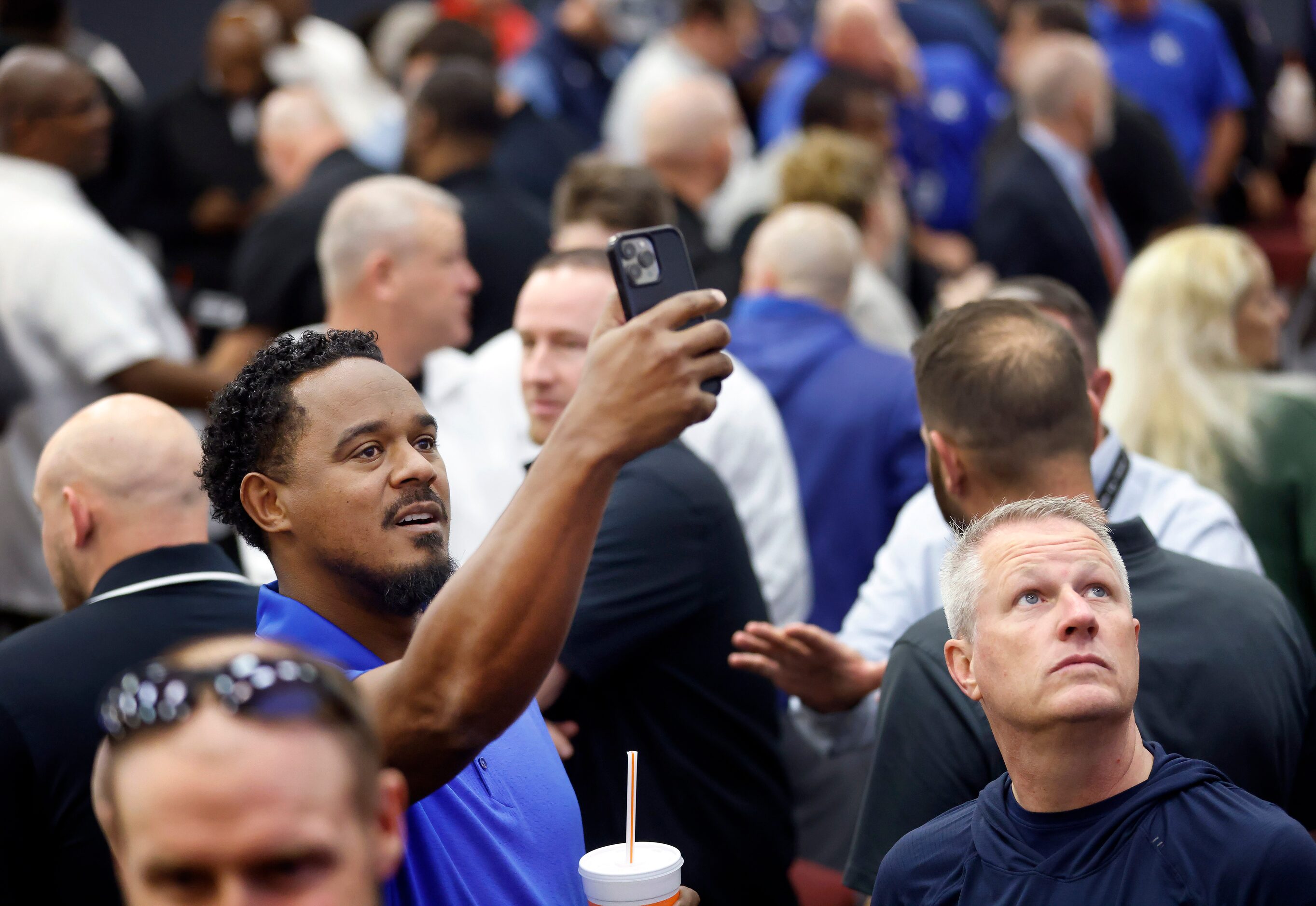 Tyler High offensive coordinator Lionel Wrenn points his phone at a QR code to view the...