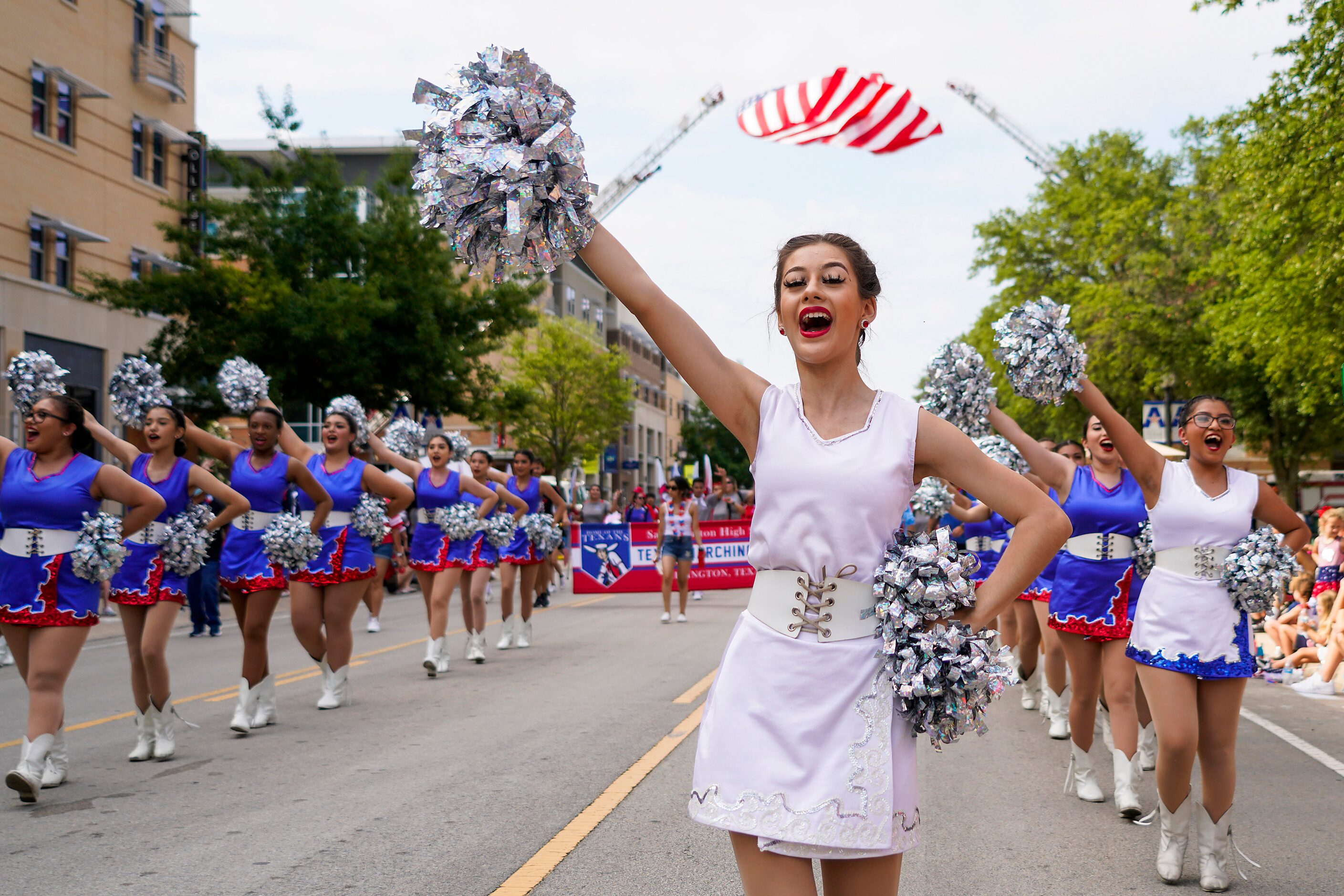 Members of the Arlington Sam Houston High School Tex-Annes drill team march in the Arlington...