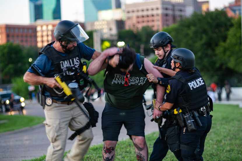 Dallas police Sgt. Roger Rudloff (left) is shown grabbing Parker Nevills by his ponytail as...