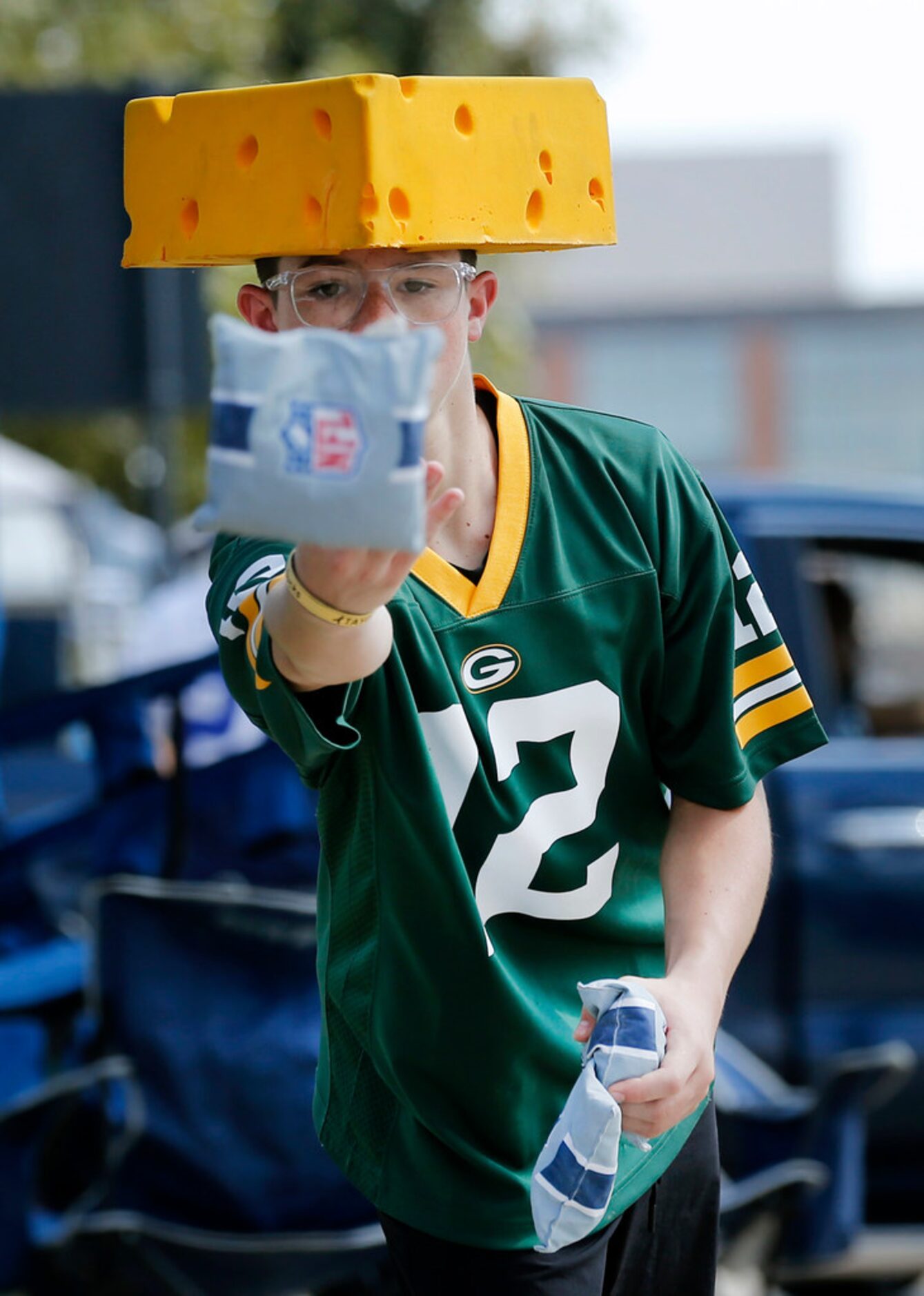 Green Bay Packers fan Daxston Swimmer of Plains, TX tosses corn bags during a game of corn...