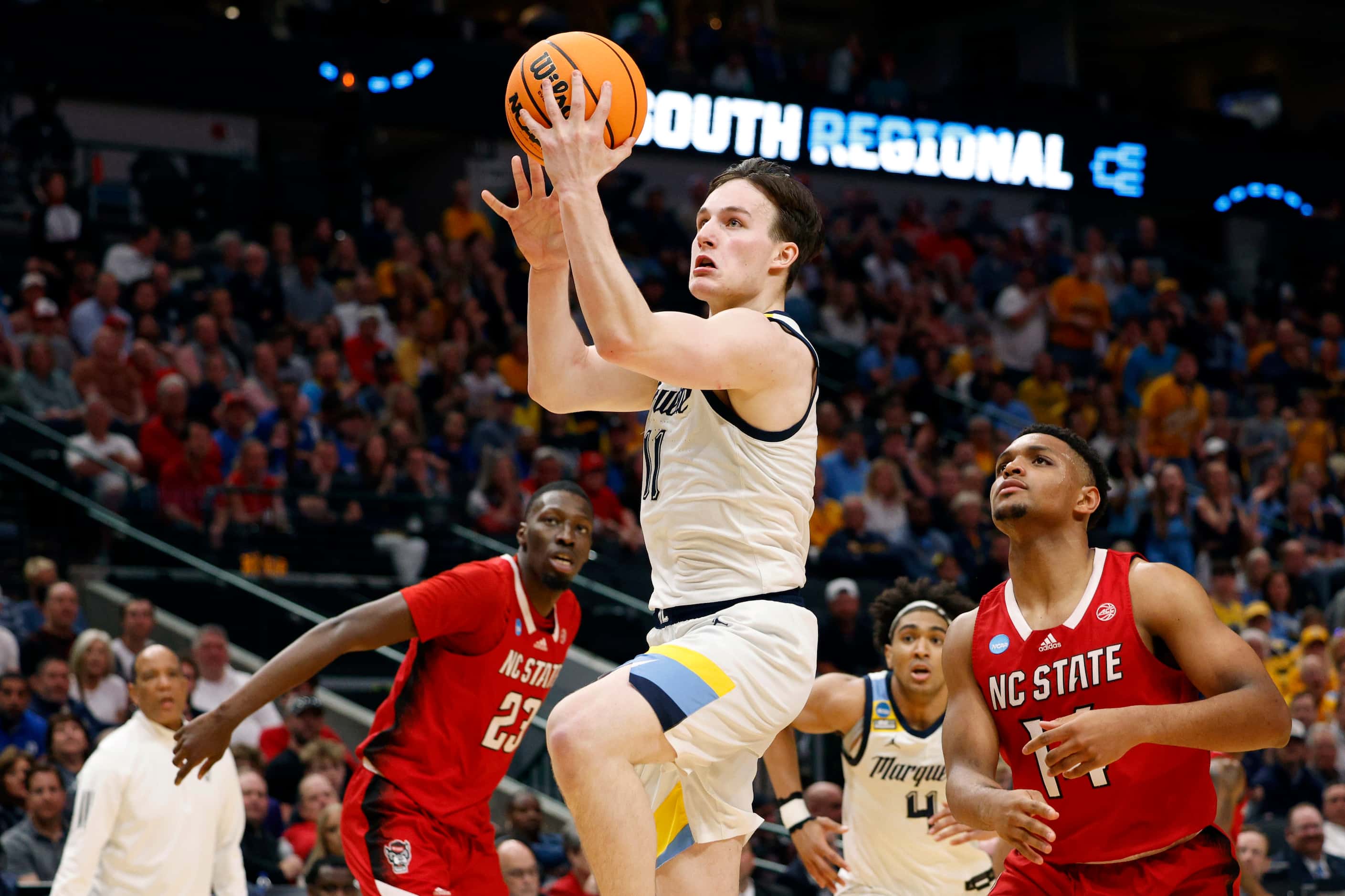 Marquette guard Tyler Kolek (11) drives to the basket past North Carolina State guard Casey...