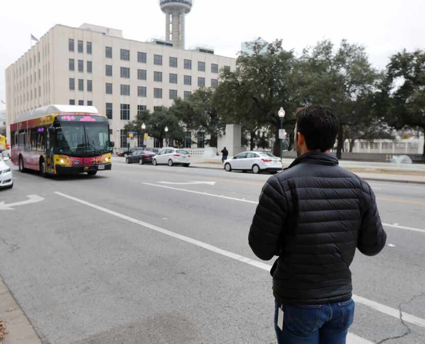 Brendan Meyer waits for a DART bus on Houston St. that passed him by without stopping as he...