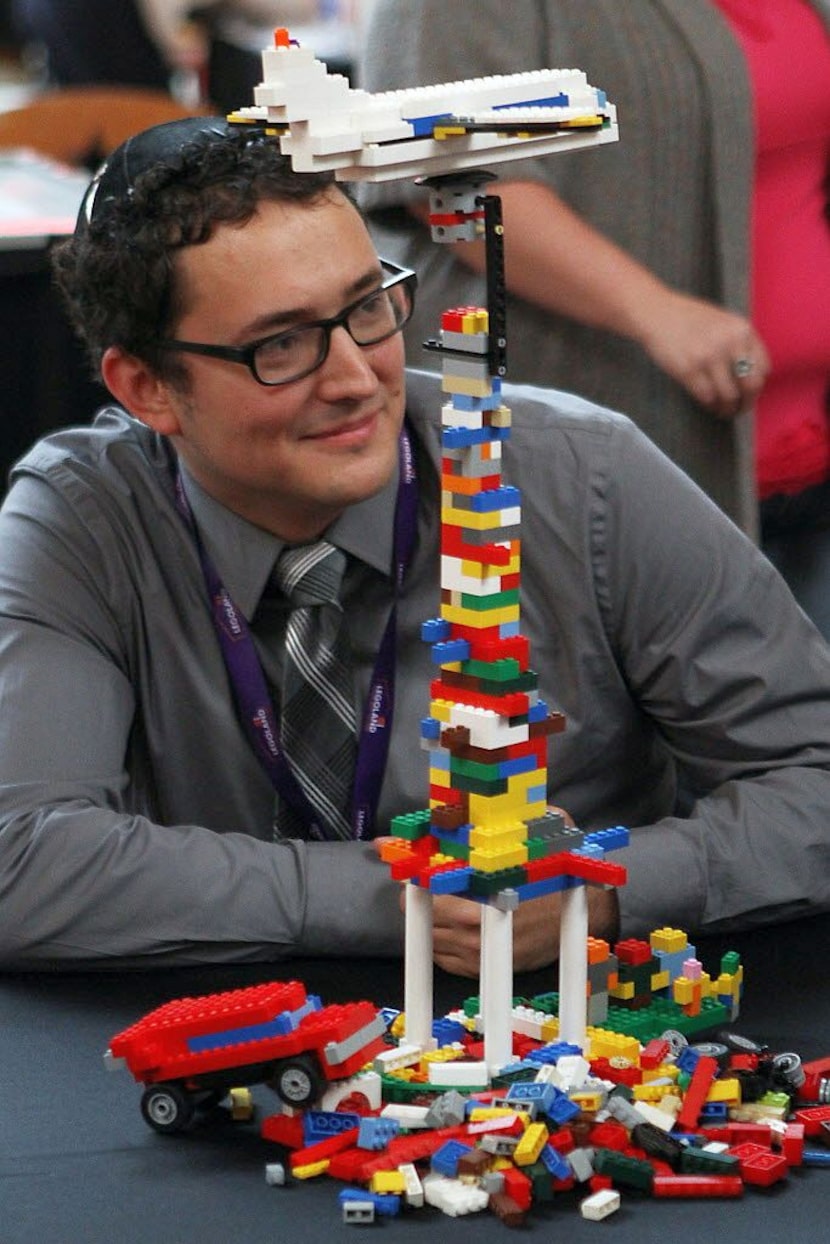 Brandon Wike, 29, of Plano, poses for photos with his winning Lego creation after winning...