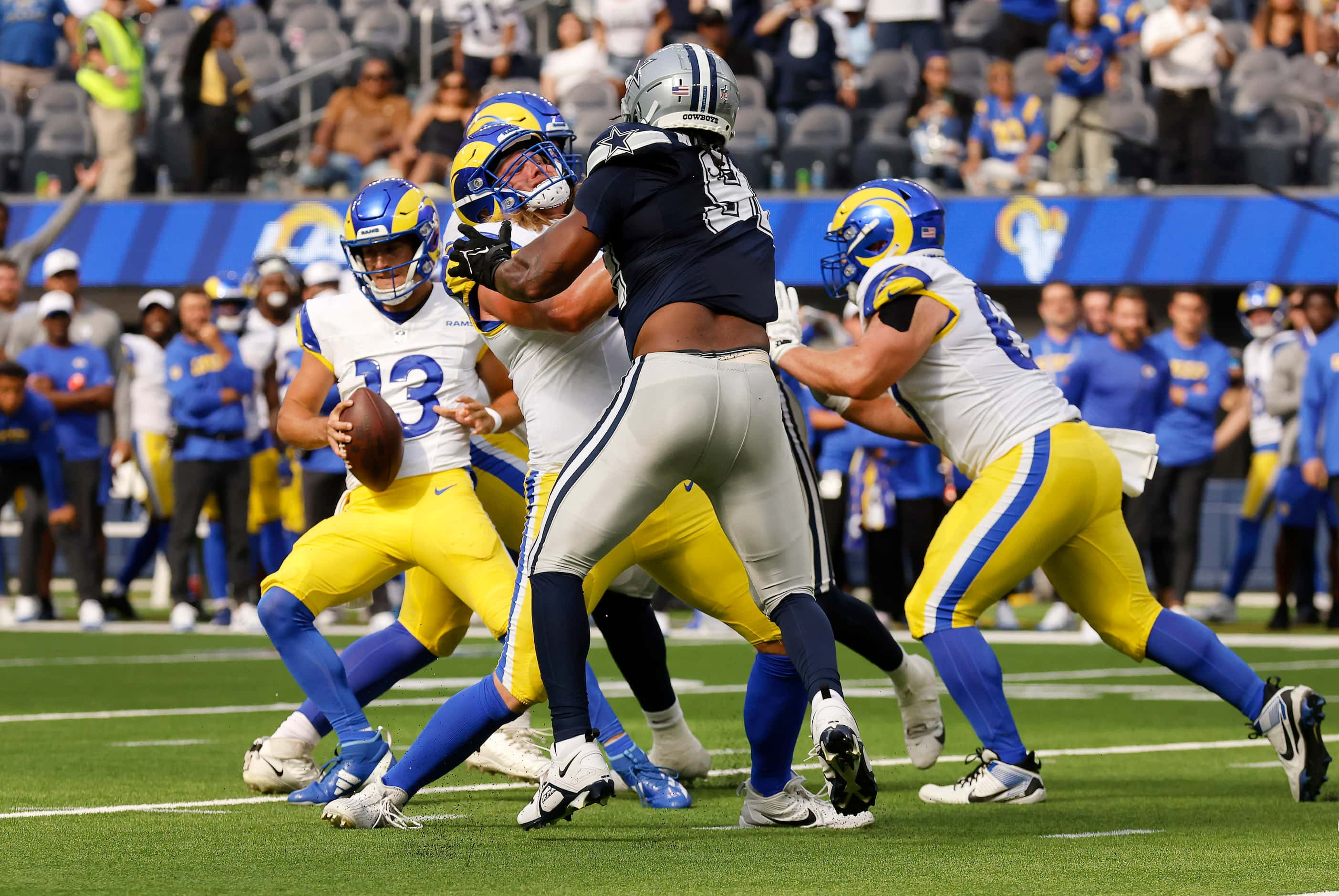 Los Angeles Rams quarterback Stetson Bennett rolls off his own lineman to get open and throw...