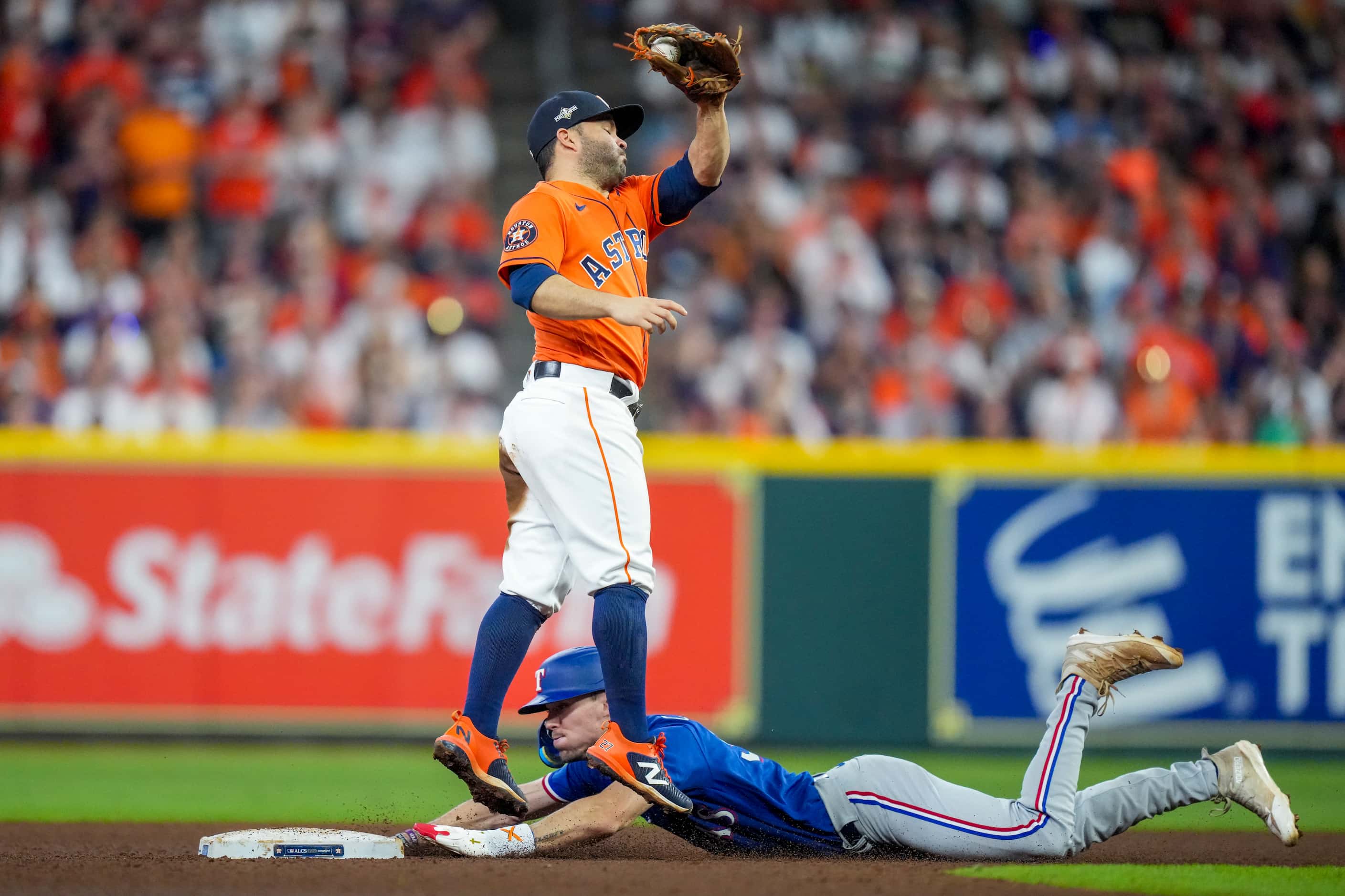 Texas Rangers left fielder Evan Carter steals second base as Houston Astros second baseman...