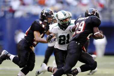 Southlake Arius Ford (21 - center) runs down to Trinty's Tray Robinson (29 - right) during a...