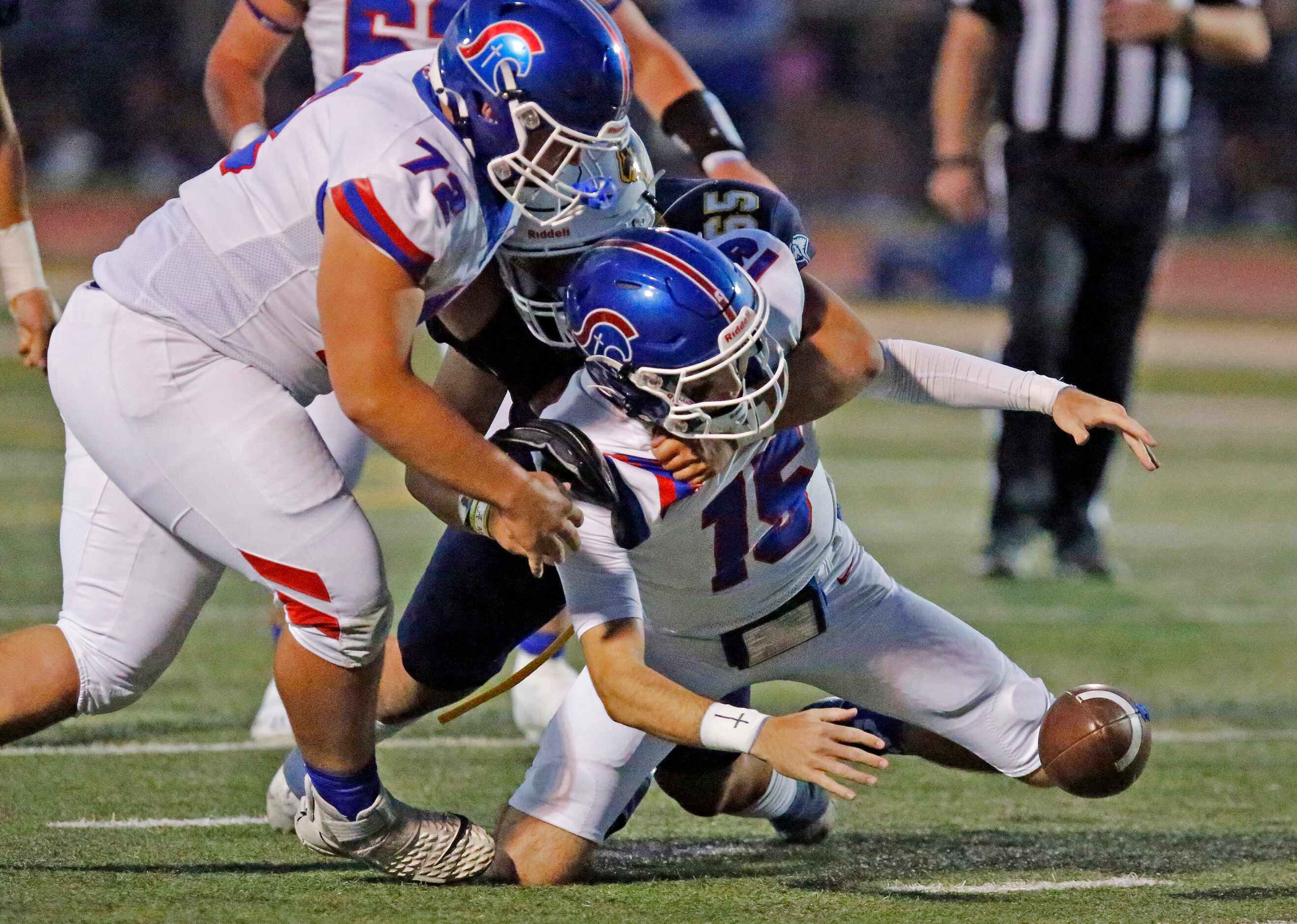 Trinity Christian Academy quarterback Aidan Mills (15) recovered his own fumble as he was...